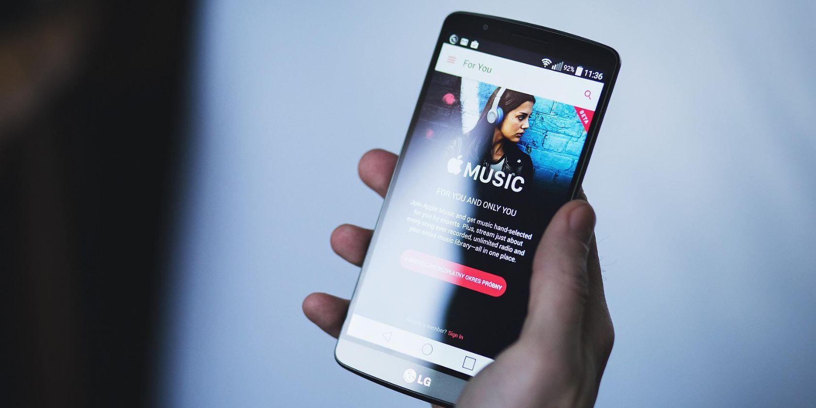 Seseorang yang memegang ponsel dengan aplikasi Apple Music di layar