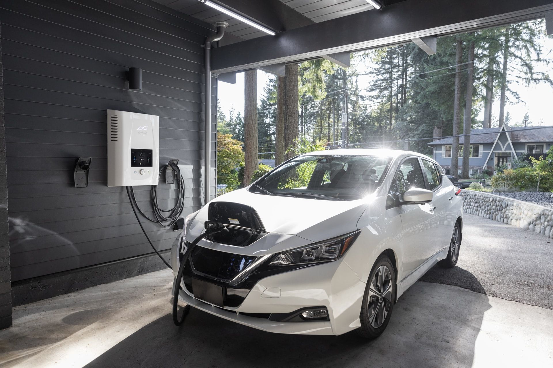 nissan leaf white mengisi daya di garasi melalui charger rumah level 2