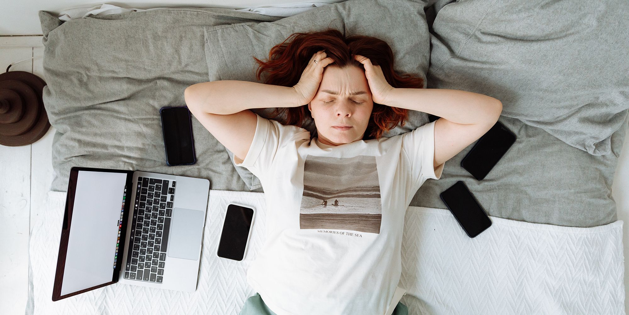 노트북으로 좌절감을 느끼며 침대에 누워 있는 여성
