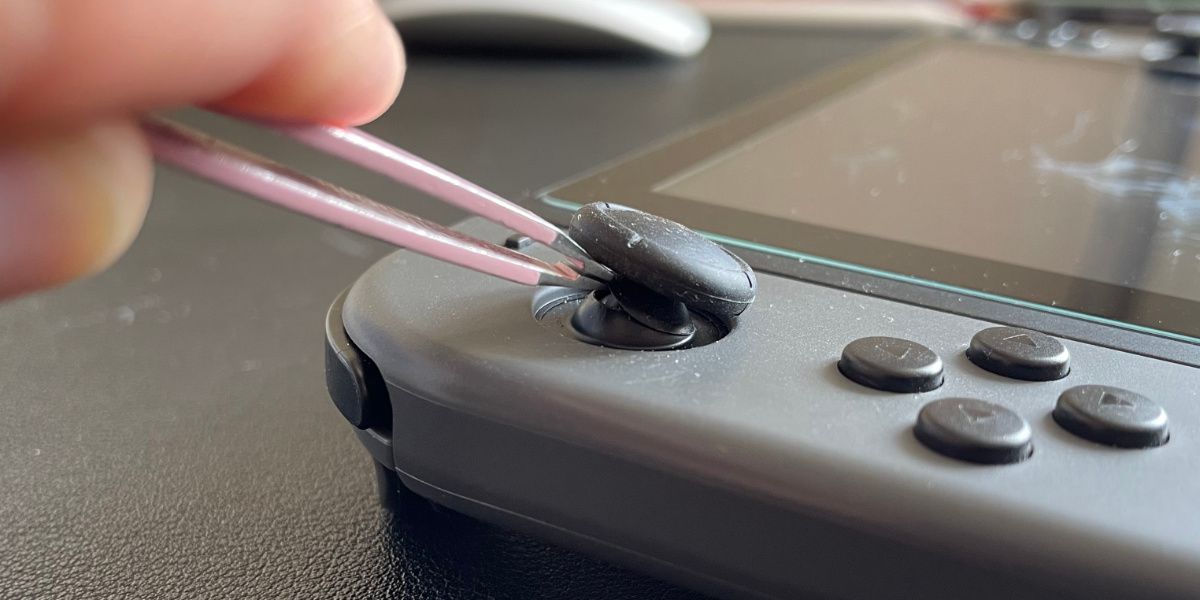 在 Nintendo Switch Joy-Con 上抬起控制桿蓋